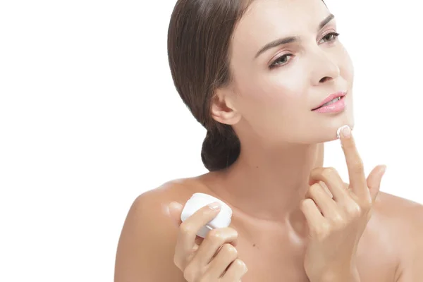 Beautiful young woman smiling while take some facial cream — Stock Photo, Image