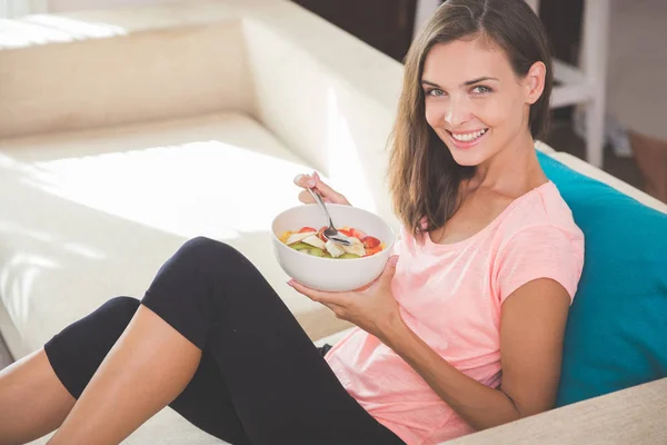 Pretty young woman having fruit salad at home — Stock Photo, Image