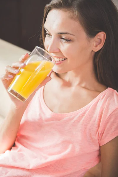 Aantrekkelijke jonge vrouw genieten van jus d'orange — Stockfoto