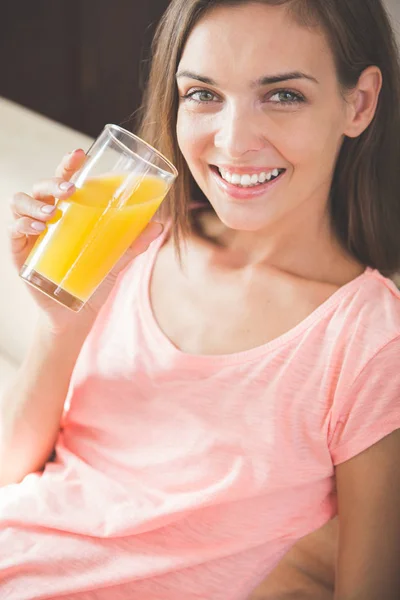 Vrouw met een glas vruchtensap thuis — Stockfoto