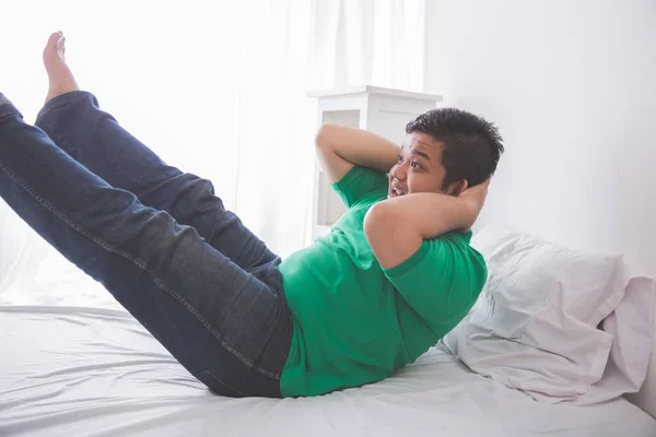 Homem obeso luta de se levantar de uma cama — Fotografia de Stock