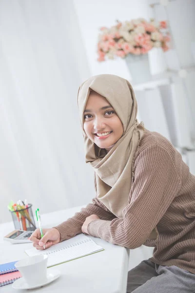 Hermosa mujer asiática estudiante con hijab haciendo tarea —  Fotos de Stock