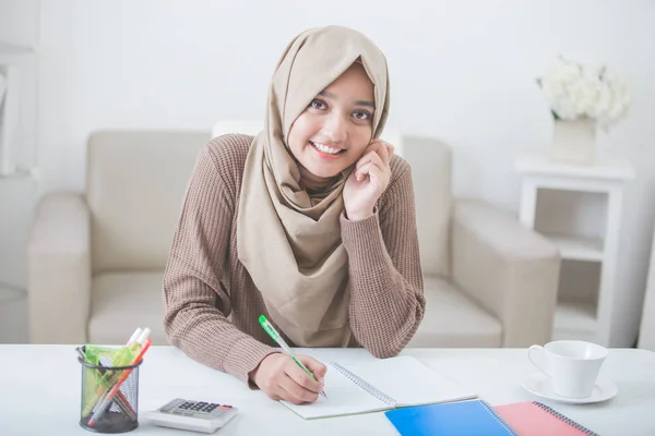 Bela fêmea asiático estudante com hijab fazendo lição de casa — Fotografia de Stock