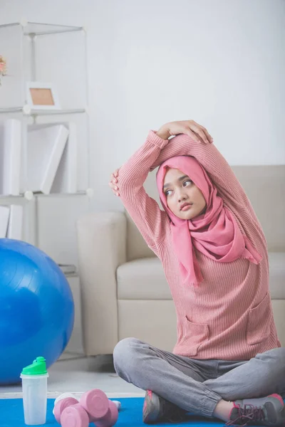 Mujer estiramiento mientras haciendo ejercicio en casa —  Fotos de Stock