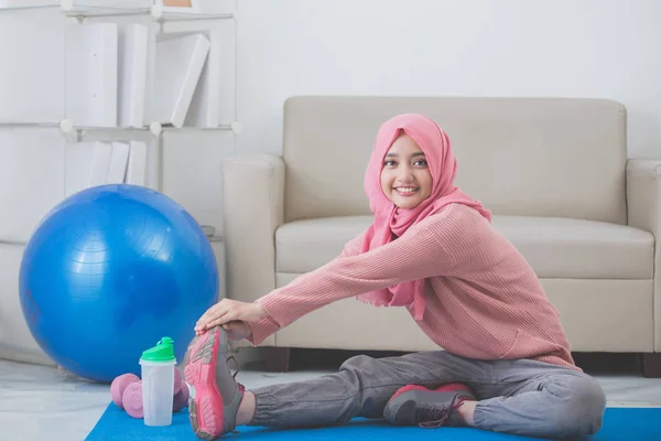 Γυναίκα, τεντώνοντας ενώ κάνει άσκηση στο σπίτι — Φωτογραφία Αρχείου