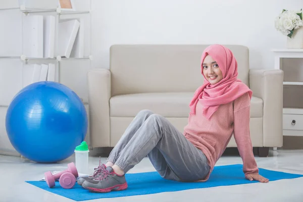 女性家で運動をしながらストレッチ — ストック写真