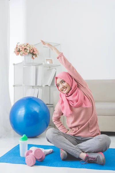 Женщина растяжения во время выполнения упражнений дома — стоковое фото