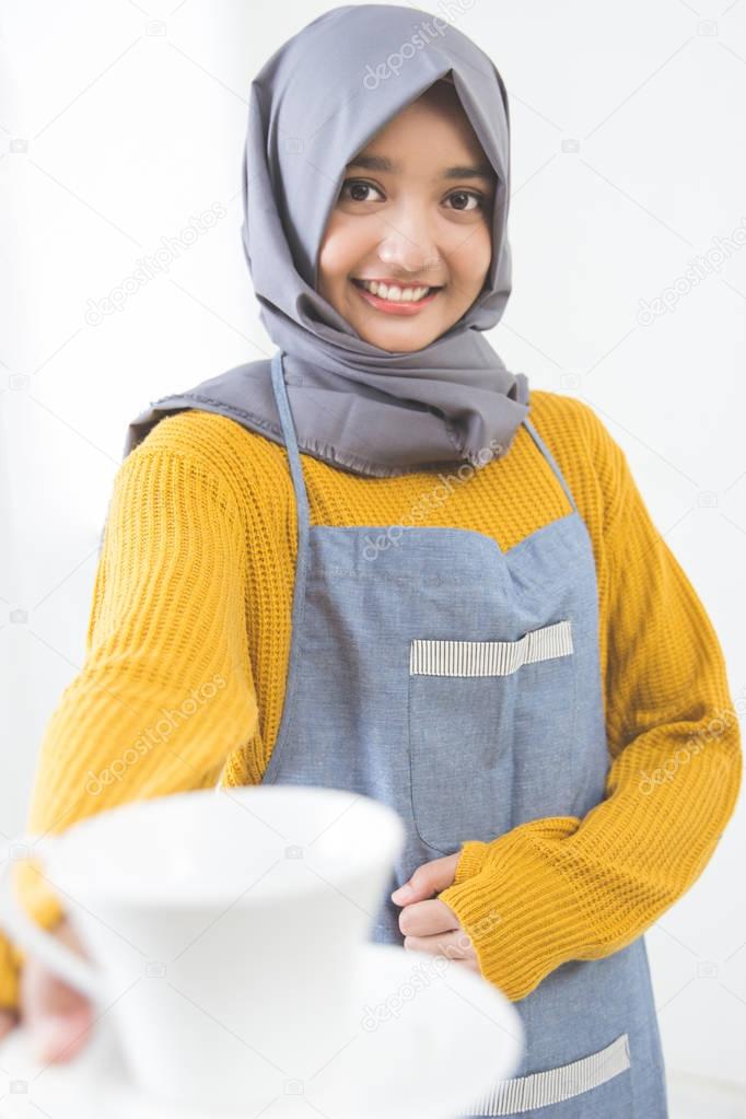 Waitress with head scarf serving coffee