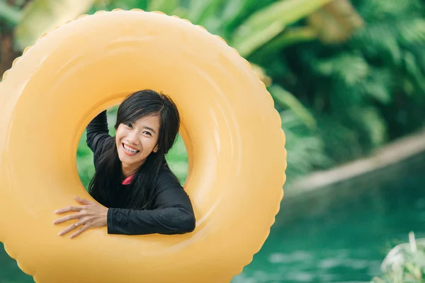 Mujer con tubo inflable en la piscina —  Fotos de Stock