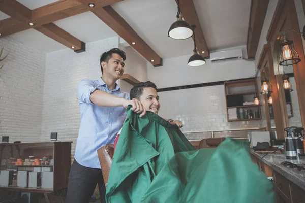Barber putting sheet to cover client — Stock Photo, Image
