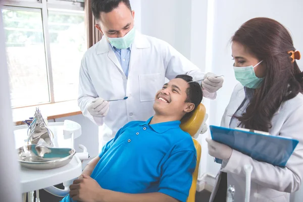 Dentistas com paciente do sexo masculino — Fotografia de Stock