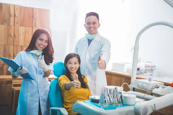 Zahnärzte mit Patient in Klinik — Stockfoto