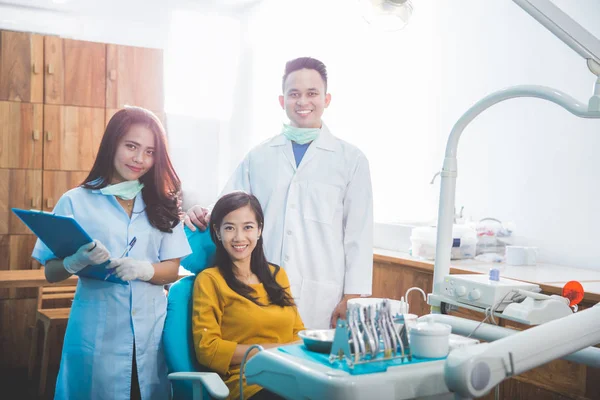 Стоматологи с пациентом в клинике — стоковое фото