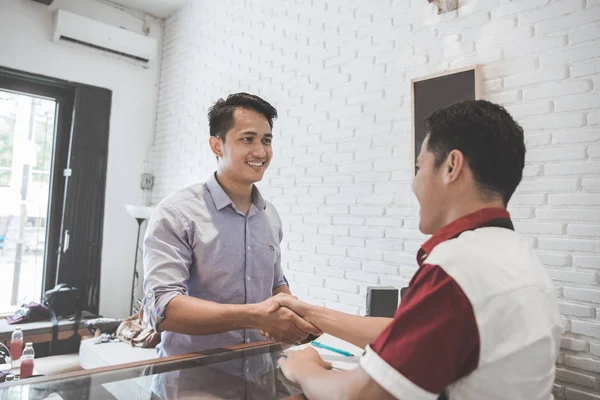 Proprietário apertando a mão do cliente — Fotografia de Stock