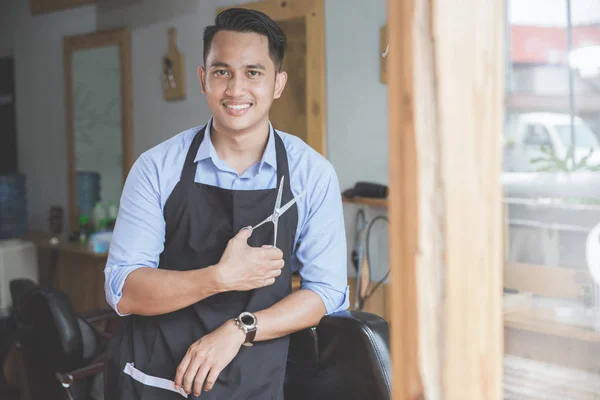 Joven peluquero experto con cortador de pelo — Foto de Stock