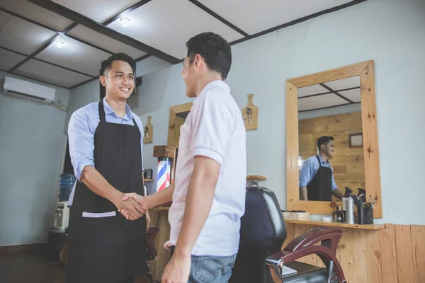 Barbeiro e cliente apertando as mãos — Fotografia de Stock