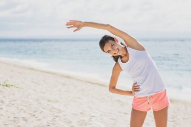 Sportif kadın vücut germe yaparken gülümseyen