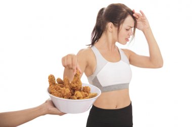 young sporty woman resisting the temptation of fried chicken clipart