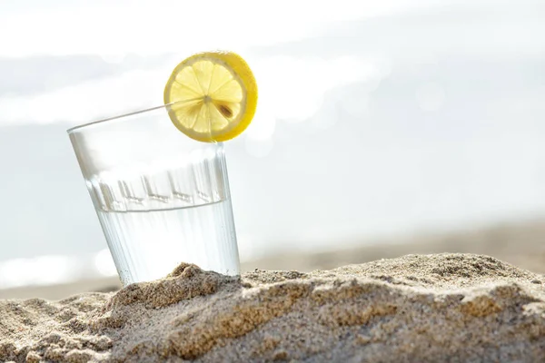 모래에 다과 대 한 생 수 한 잔 — 스톡 사진