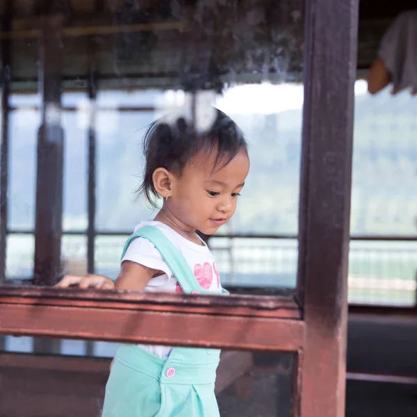 Chica caminando al lado de la ventana en casa — Foto de Stock
