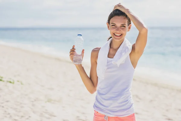Chica deportiva feliz sosteniendo una botella de agua mineral para refrescar — Foto de Stock