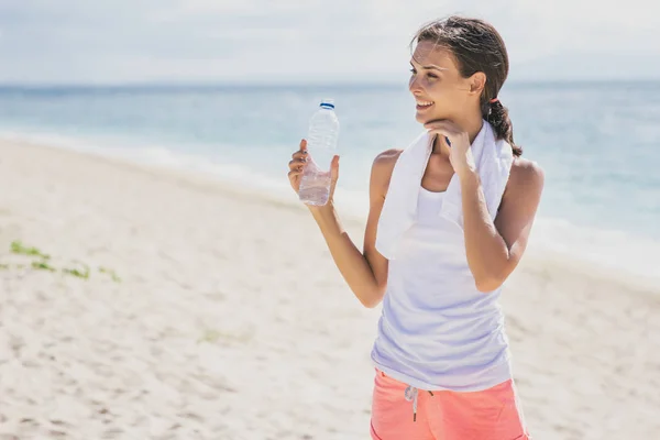 Спортивная женщина пьет минеральную воду после тренировки для новичков — стоковое фото