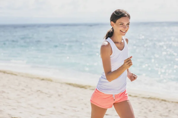 Sportieve vrouw joggen op het strand — Stockfoto