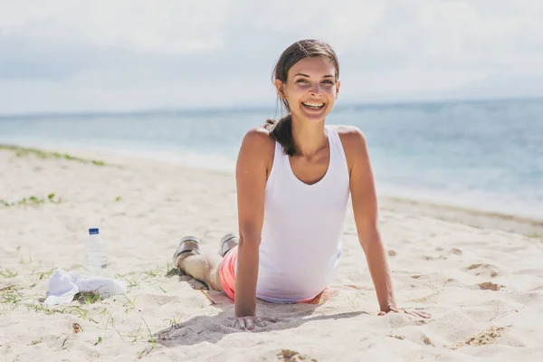 Happy healthy woman doing push up at the beach — Stock Photo, Image