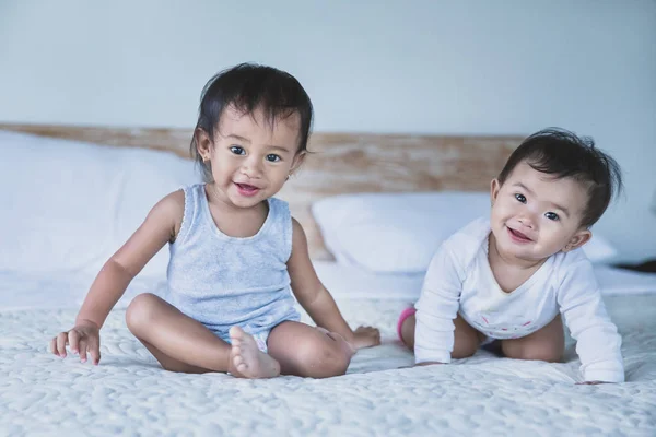 Дві милі дитини сидять на ліжку — стокове фото