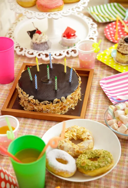 Pastel de queso de chocolate, rosquillas, mini pastel y malvavisco en tabl — Foto de Stock