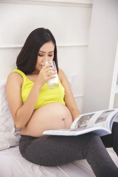 Mulher grávida leitura revista — Fotografia de Stock