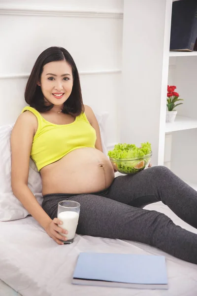 Mujer embarazada desayunando en el dormitorio — Foto de Stock