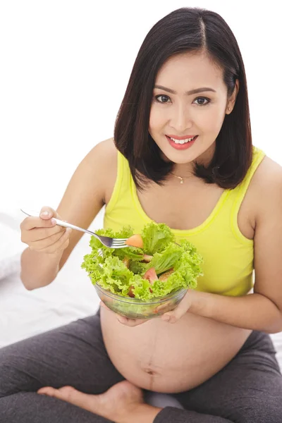 Беременная женщина ест здоровый салат — стоковое фото