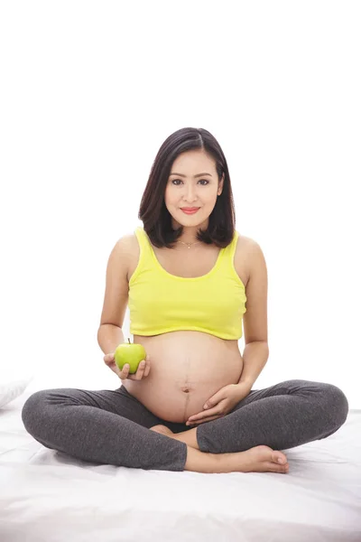 Здоровая беременная женщина держит яблоко — стоковое фото