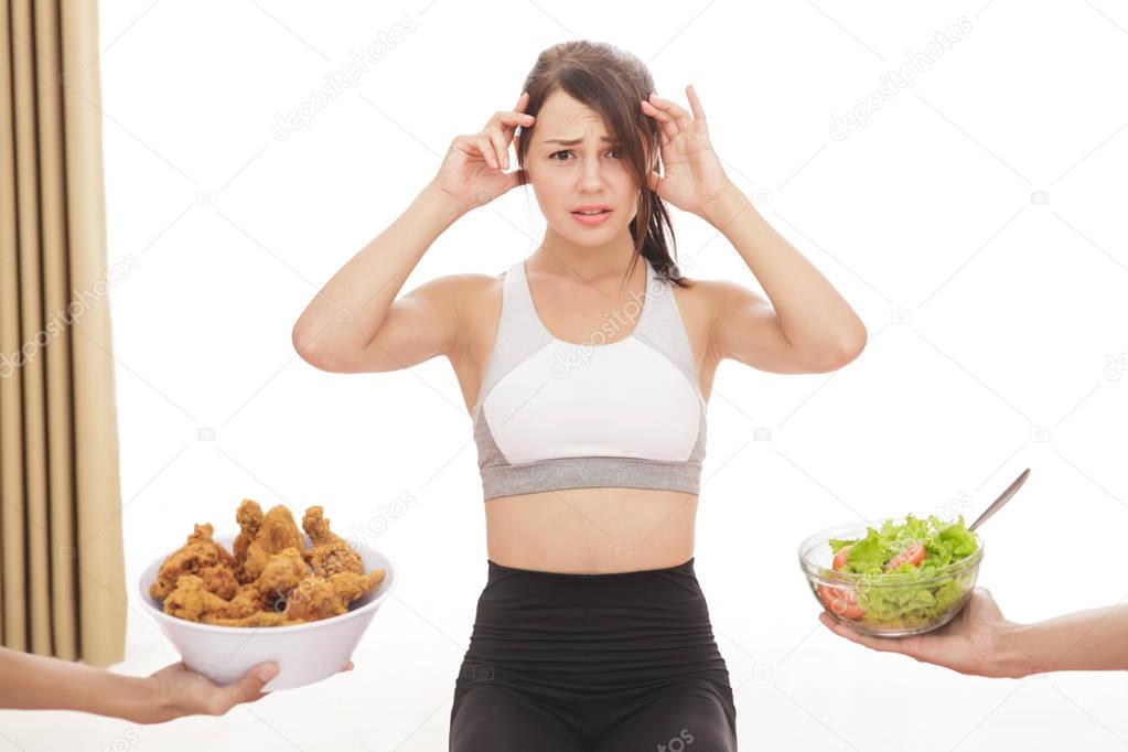 sporty girl confuse to choose a meal on diet process