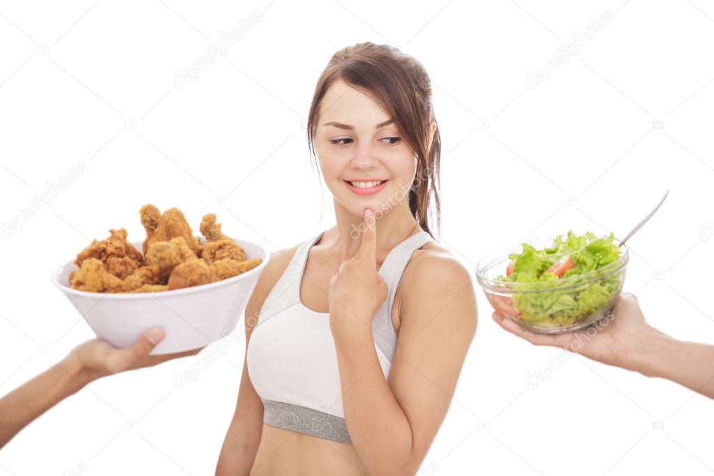 sporty girl on diet process looking on salad than fried chicken