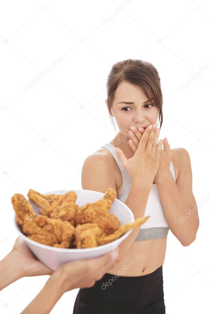 young sporty woman resisting the temptation of fried chicken