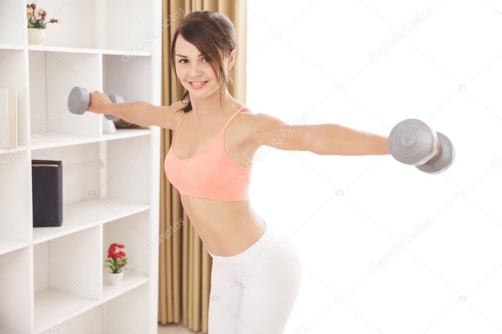 cheerful sporty woman workout using dumbbells