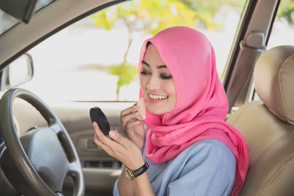 Wanita cantik menerapkan bubuk wajah di dalam mobil — Stok Foto