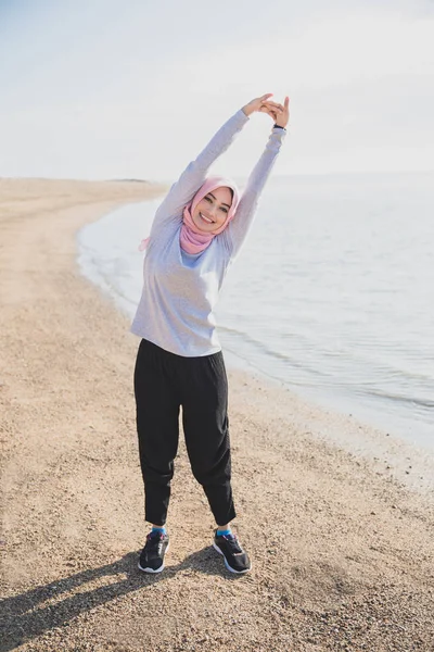 Feliz asiático mujer usando hijab haciendo brazos estiramiento —  Fotos de Stock