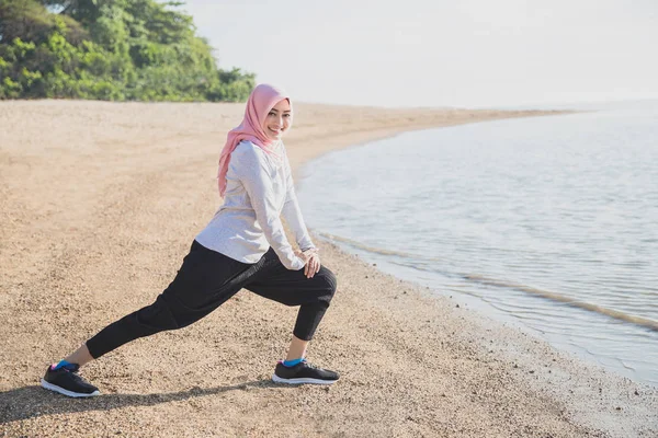 Asiático deportivo mujer usando hijab haciendo pierna estiramiento —  Fotos de Stock