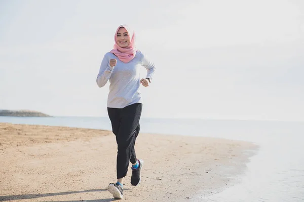 Sportliche Frau im Hijab lächelt beim Joggen — Stockfoto