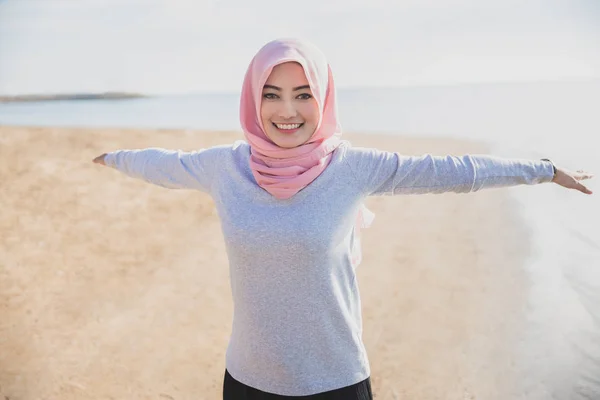 Hermosa mujer deportiva usando hijab sonriendo mientras se entrena —  Fotos de Stock