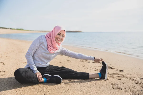 Mujer deportiva saludable usando hijab sonriendo mientras hace stret pierna —  Fotos de Stock