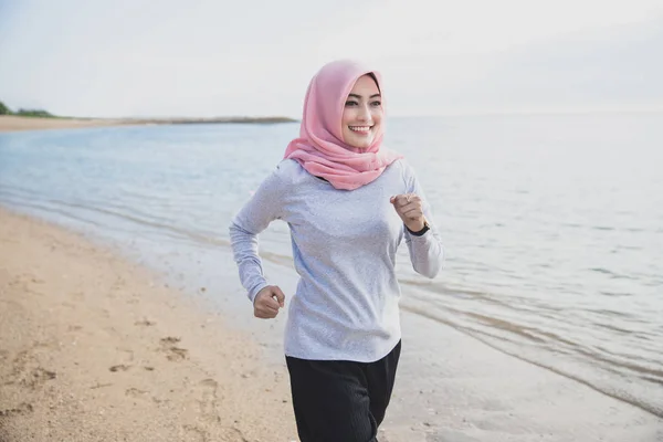 Mujer deportiva con hijab sonriendo mientras trota — Foto de Stock