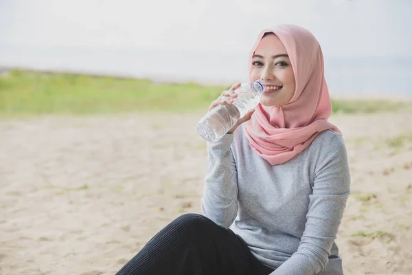 Wanita sporty mengenakan hijab air mineral sementara mengambil r — Stok Foto