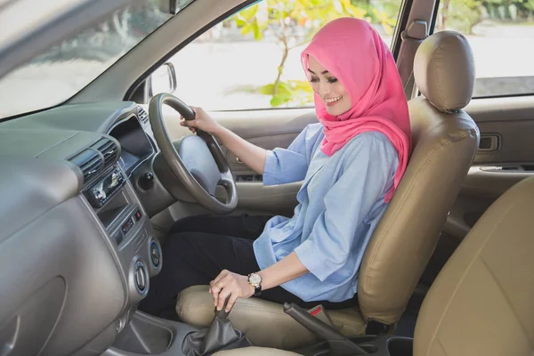 Asian woman wearing hijab driving a car and shifting the gearshi — Stock Photo, Image