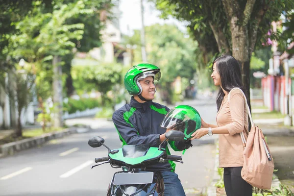 Motorista de motocicleta dando capacete ao cliente — Fotografia de Stock