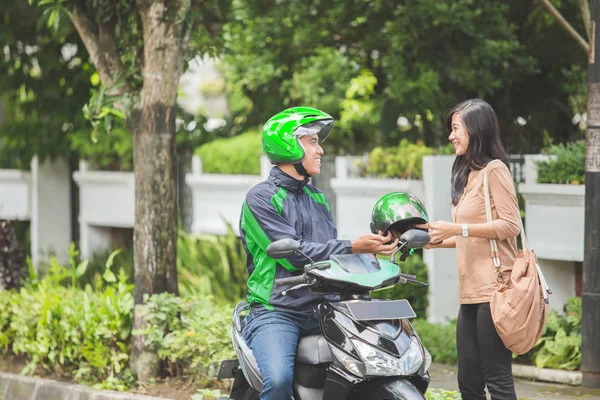 Motosiklet sürücüsü kask müşteriye verilmesi — Stok fotoğraf