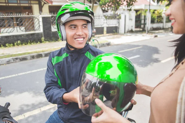 Motorcycle driver giving helmet to customer — Stock Photo, Image